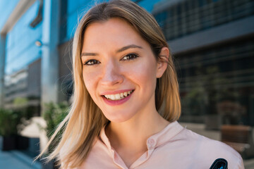 Business woman standing outside office buildings.