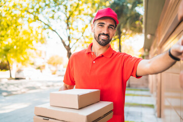 Delivery man with pizza box ringing house doorbell..