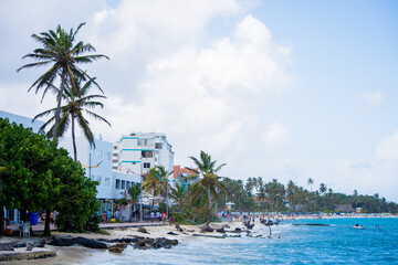 Landscape of the beach of San Andres island and Providencia Archipelago in Colombia with blue ocean, palm trees, and turistic hotels and buildings