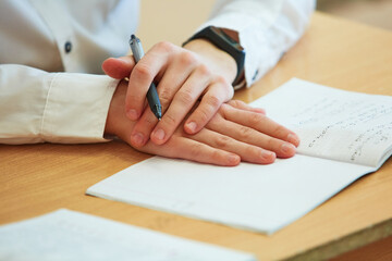 men's hands with a pen write on a Notepad