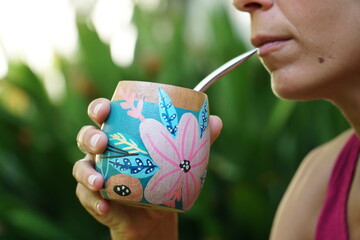 Mujer tomando un mate con bombilla 