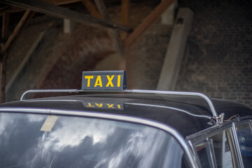 A selective focus shot of a taxi sign on a car