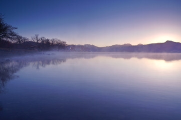 Fototapeta na wymiar うっすらと靄の掛かった夕暮れの湖畔