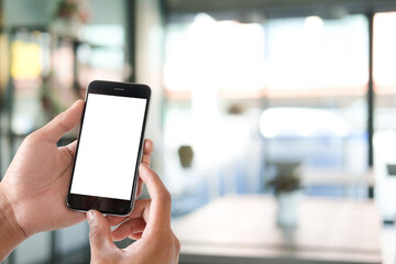 Close up view of male hands using smart phone with modern office blurred background. 