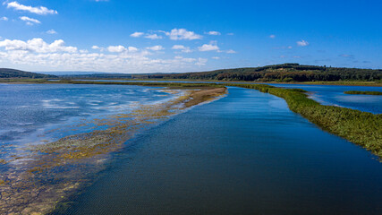 A panoramic shot from Durugol Turkey. There is a lake in the middle of a path filled with forest under the blue sky