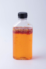 Chicken dipping sauce in a bottle made from sweet hot chili on white background.