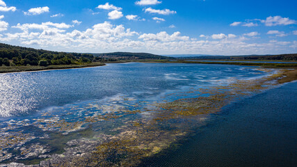 A panoramic shot from Durugol Turkey. There is a lake in the middle of a path filled with forest under the blue sky