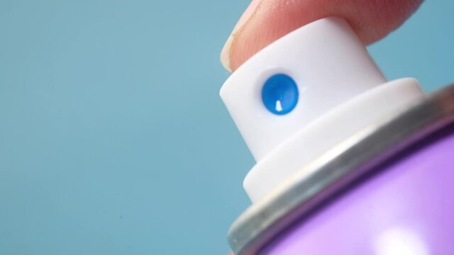 hand pressing a spray bottle with liquid 