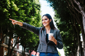 latin woman outdoor in the city hailing a taxi in a colonial city of latin america