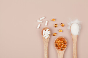 Supplements for health , vitamin D zinc and vitamin C powder in wooden spoons on beige background. copy space top view .healthy lifestyle concept. 