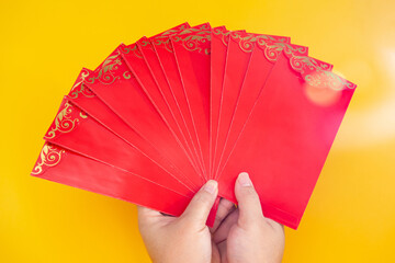 Tet Holiday.Lunar New Year.Chinese New Year . Woman hand holding a pack of red envelope  