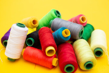 Color sewing threads on yellow background 