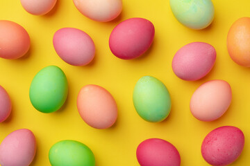 Painted Easter eggs on yellow background top view