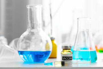 Vaccine in vial for injection on table against background of laboratory