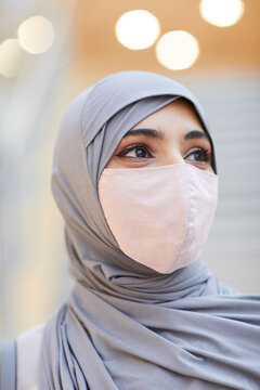 Vertical Close Up Portrait Of Modern Middle-Eastern Woman Wearing Mask And Headscarf While Posing In Shopping Mall