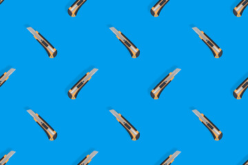 Stationery knives seamless pattern on a blue background.