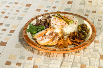 Plate of rice and chicken breast with mushrooms and vegetables