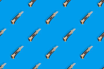 Stationery knives seamless pattern on a blue background.