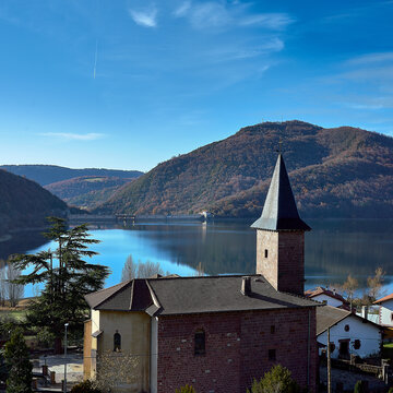 Church of Eugi with the reservoir and mountains.