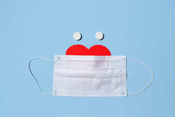 Creative concept Valentine's Day and new normal 2021. Face from medical mask, heart and two pills....