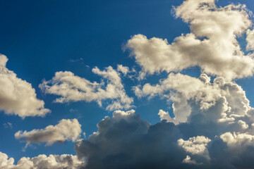 Naklejka na ściany i meble Lush white clouds against blue sunny sky