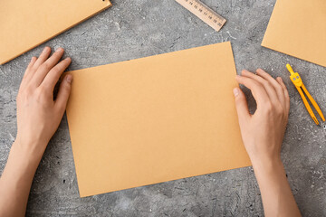 Female hands with blank paper on dark background