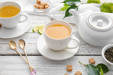 Composition with cups of green tea and lime on table