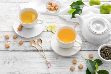 Composition with cups of green tea and lime on table