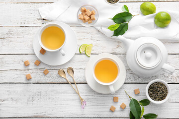 Composition with cups of green tea and lime on table