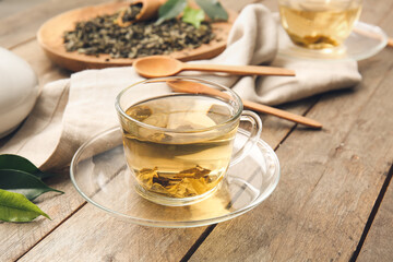 Composition with cup of green tea on wooden table