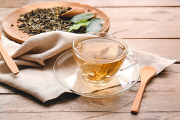 Composition with cup of green tea on wooden table