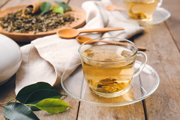 Composition with cup of green tea on wooden table
