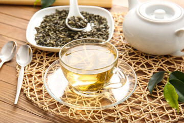 Composition with cup of green tea on wooden table