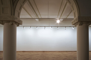 Interior of a empty white wall with spot lights at art gallery