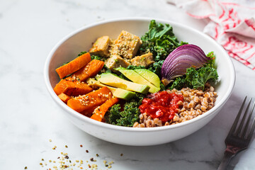 Baked vegetables, avocado, tofu and buckwheat buddha bowl. Vegan lunch salad with kale, baked sweet...