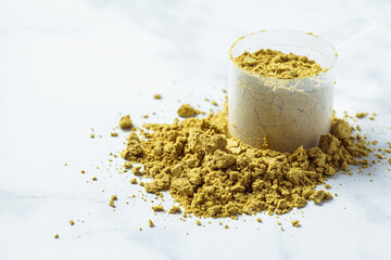 Vegan hemp protein powder on white marble background, copy space. Vegan protein concept.