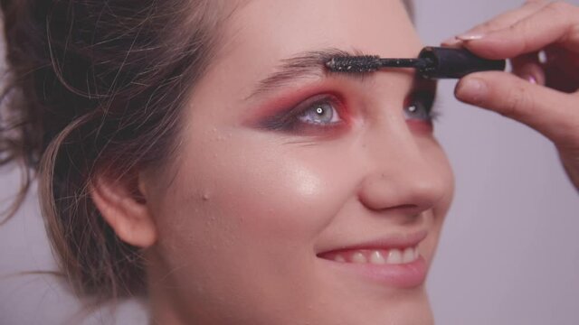 The make-up artist shades the model's eyebrows