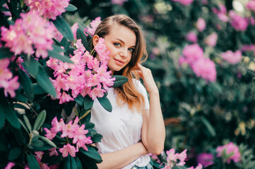 Naklejka premium Young beautiful girl posing among the flowering tree
