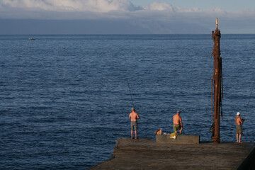 A mesmerizing shot of an ocean or a sea with fish hunters on the cloudy sky background