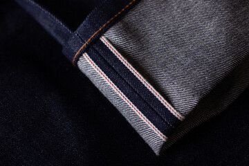 Dry denim jeans red selvedge close-up. Classic raw japan or american redline selvage denim jeans.