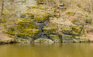 mossy rocks over a river shore