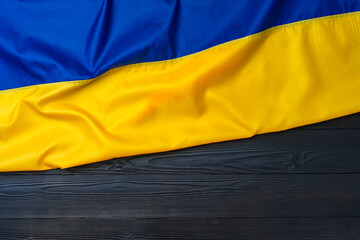 National flag of Ukraine on dark wooden background