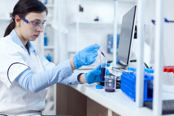 Fototapeta premium Woman scientist in lab during clinic experiement taking sample of genetic material using pipette. Chemistry researcher in sterile laboratory using modern technology to test microbiology liquid.