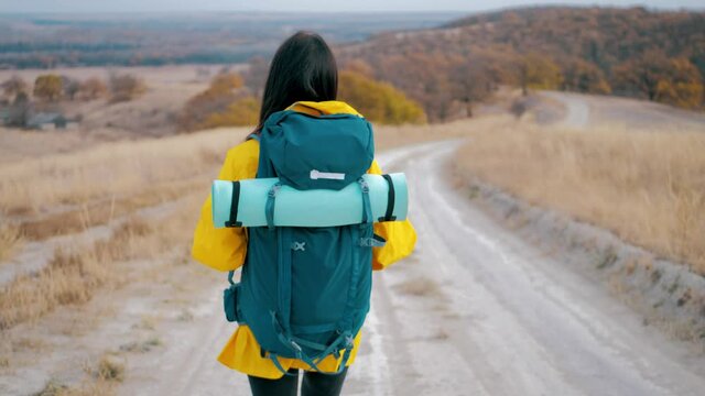 Woman traveler with backpack exploring on top of mountains. Wanderlust and travel concept.