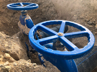 Valves on pipeline in ground. Pipe valves in trench