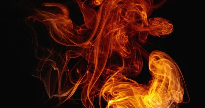 Surreal slow dance of clouds of colored smoke. Swirls of fabulous smoke on a dark background. Abstract colored tongues of flame. Slow motion.