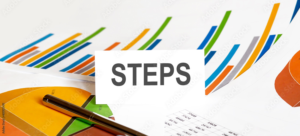 Aufkleber steps text on paper on chart background with pen