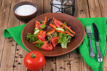 Salad from fresh vegetables in ceramic bowl