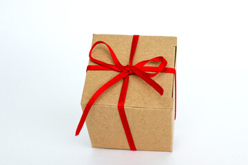 Gift box with red ribbon isolated on white. The concept of gifts for the holidays. Christmas and New Year. Cardboard box decorated with a red ribbon.