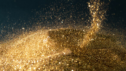 Glittering gold powder sprinkled on a pile of gold on a black background